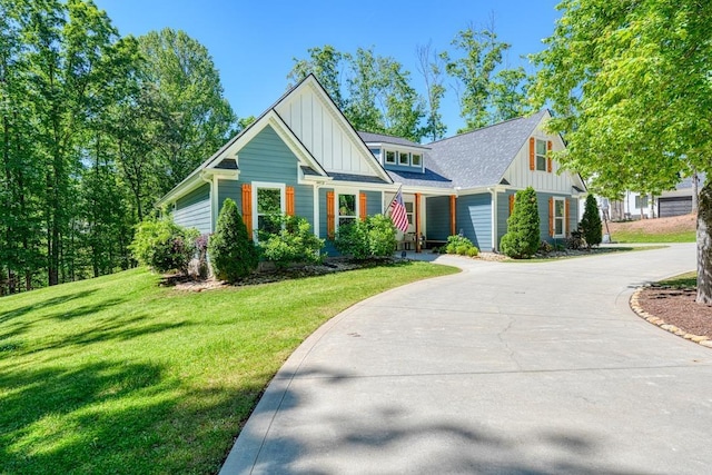 craftsman inspired home with board and batten siding, concrete driveway, and a front yard