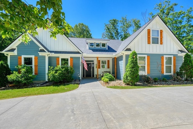 modern farmhouse style home featuring board and batten siding and roof with shingles