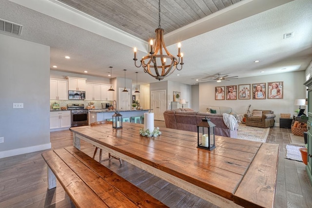 dining room featuring ceiling fan, recessed lighting, a chandelier, hardwood / wood-style floors, and baseboards