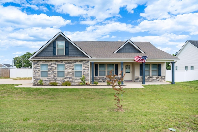 craftsman-style home with stone siding, roof with shingles, and covered porch