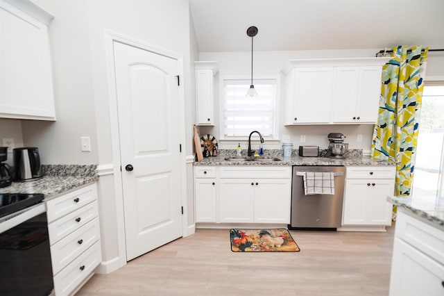 kitchen with stainless steel dishwasher, a sink, range with gas stovetop, light wood-type flooring, and white cabinets