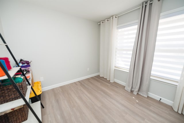 unfurnished room featuring light wood finished floors and baseboards