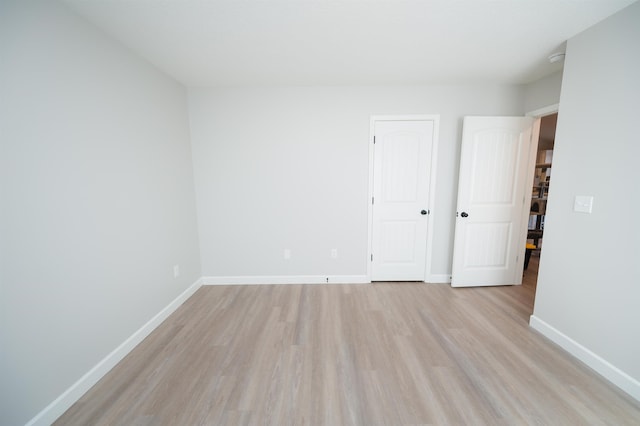 unfurnished room featuring light wood-style flooring and baseboards