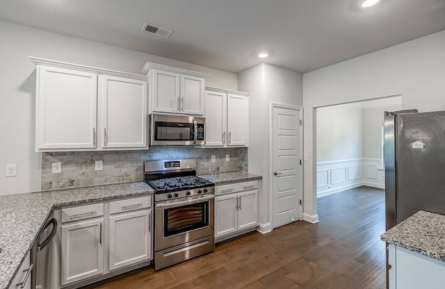 kitchen featuring stainless steel appliances, dark wood finished floors, white cabinets, backsplash, and recessed lighting