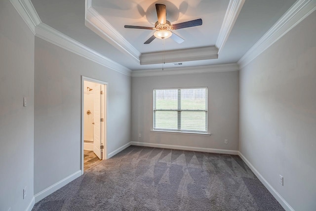 carpeted empty room with a raised ceiling, ornamental molding, ceiling fan, and baseboards