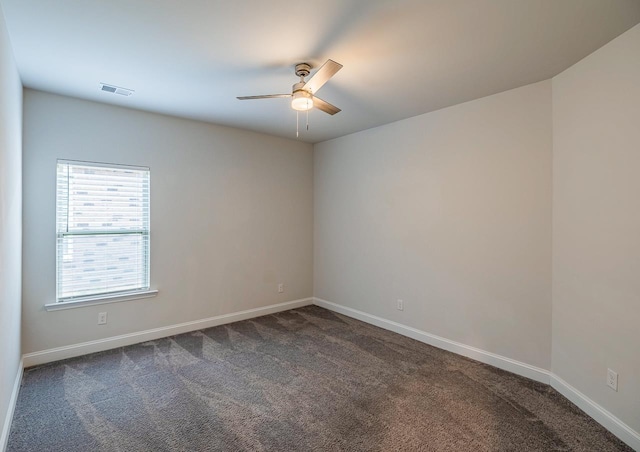 empty room featuring ceiling fan, dark carpet, and baseboards