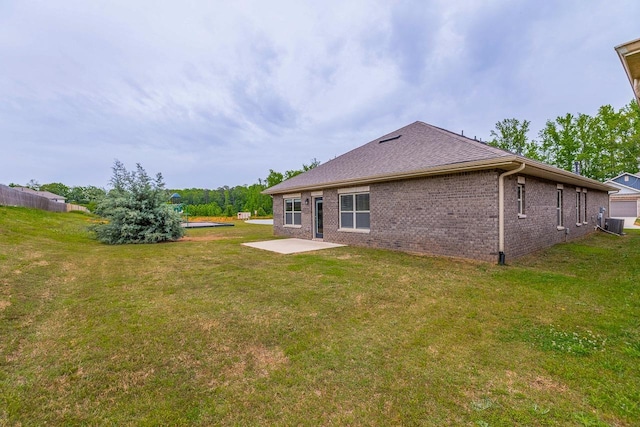 back of property featuring a patio, brick siding, and a yard