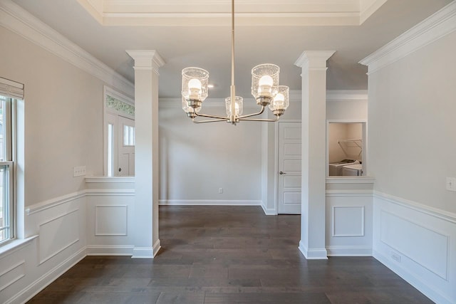unfurnished dining area with plenty of natural light, washer and clothes dryer, a chandelier, a decorative wall, and dark wood-type flooring