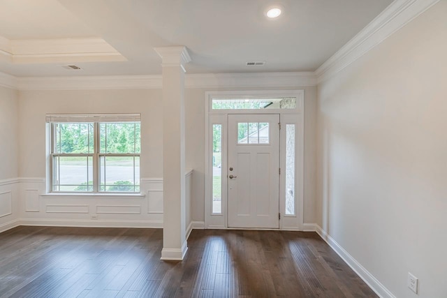 foyer featuring plenty of natural light, decorative columns, dark wood finished floors, ornamental molding, and a wainscoted wall