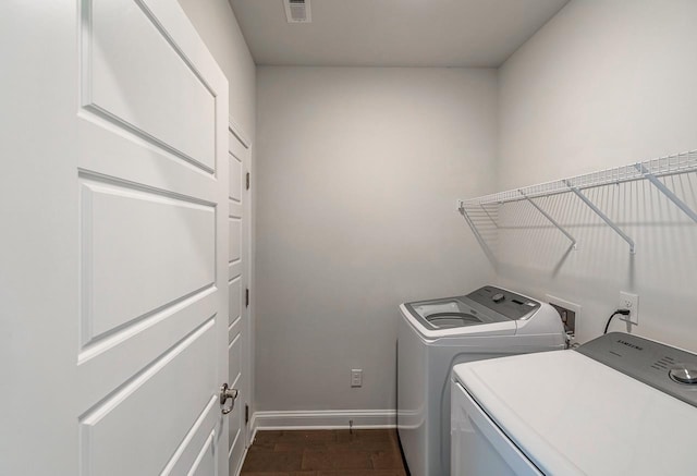 laundry room with independent washer and dryer and baseboards