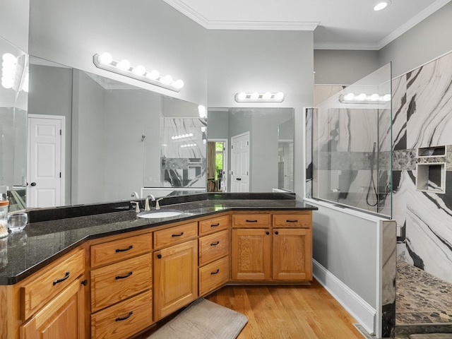 bathroom featuring walk in shower, ornamental molding, wood finished floors, and vanity