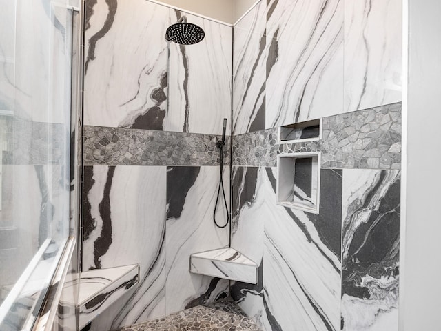 full bathroom featuring a marble finish shower
