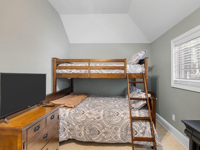 bedroom featuring lofted ceiling and baseboards