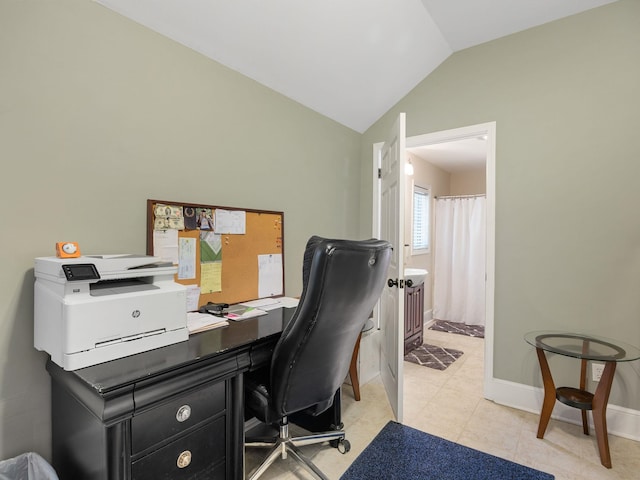 home office with lofted ceiling, baseboards, and light tile patterned flooring