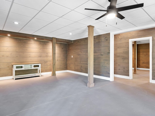 finished below grade area with wood walls, ceiling fan, baseboards, and recessed lighting