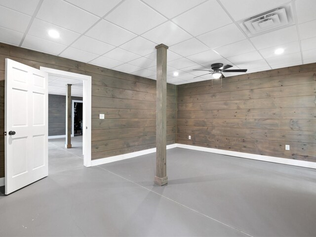finished basement with wooden walls, recessed lighting, a paneled ceiling, and baseboards