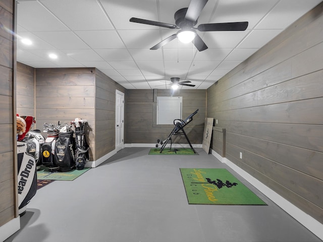 game room with wooden walls, finished concrete flooring, a ceiling fan, recessed lighting, and a paneled ceiling