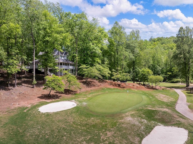 view of property's community featuring an area to practice putting and golf course view