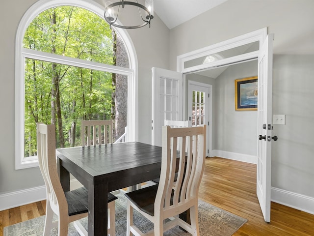 dining room with lofted ceiling, french doors, a chandelier, and plenty of natural light