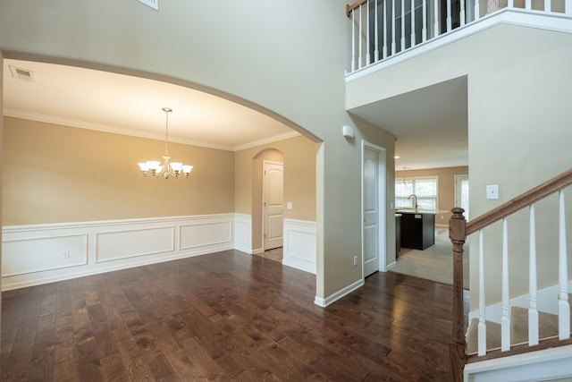 173 Tiara Rdg, Duncan, SC 29334 - spare room featuring dark wood-type flooring, a chandelier, crown molding, wainscoting, and stairs