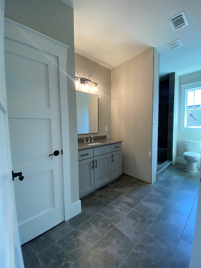 full bath with vanity, toilet, and a shower