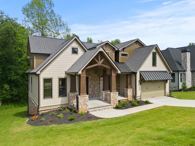 craftsman-style house with driveway, a standing seam roof, a front lawn, an attached garage, and stone siding