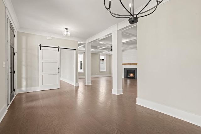 basement with a barn door, baseboards, dark wood-style floors, a fireplace, and a ceiling fan