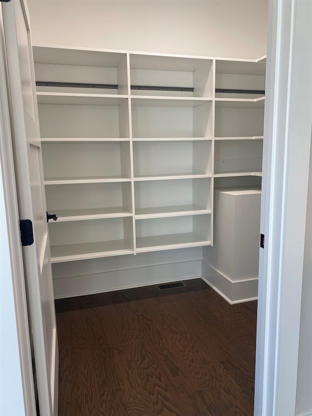 spacious closet with dark wood-style floors