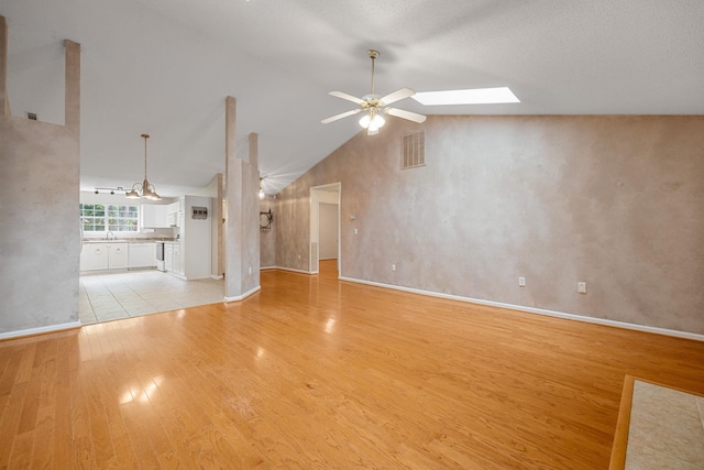 2 Birch Tree, Greer, SC 29651 - unfurnished living room featuring light wood-type flooring, a ceiling fan, baseboards, lofted ceiling, and a skylight