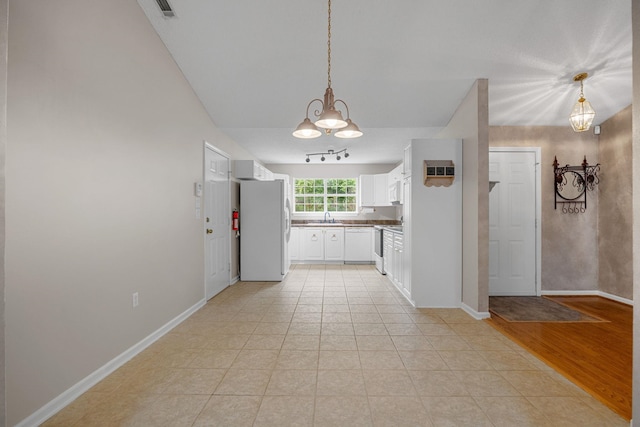 2 Birch Tree, Greer, SC 29651 - kitchen featuring freestanding refrigerator, a sink, white cabinets, hanging light fixtures, and baseboards