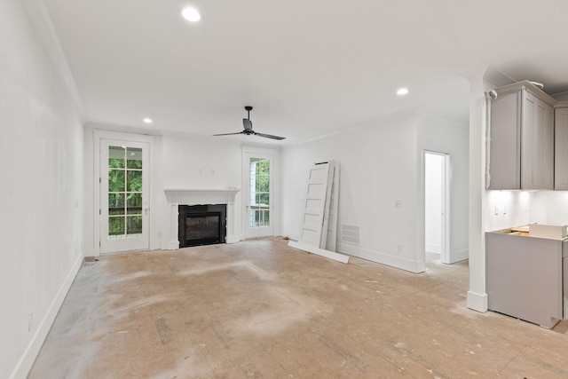 unfurnished living room with a glass covered fireplace, baseboards, ceiling fan, and recessed lighting