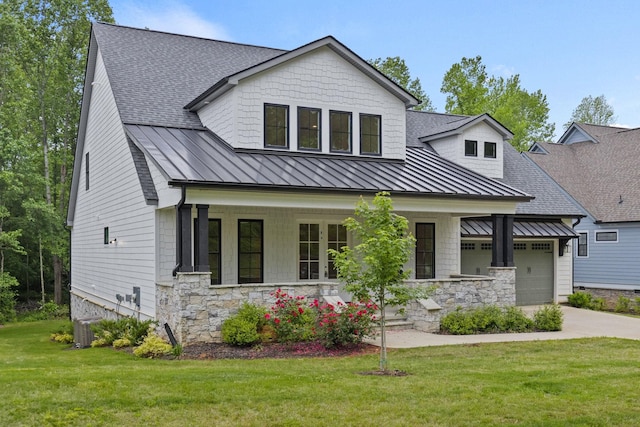 modern farmhouse with covered porch, roof with shingles, a standing seam roof, and a front yard