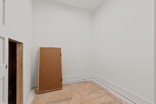 unfurnished room with baseboards