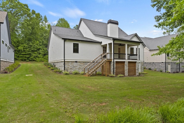 back of property featuring a ceiling fan, stairway, a yard, a chimney, and a shingled roof