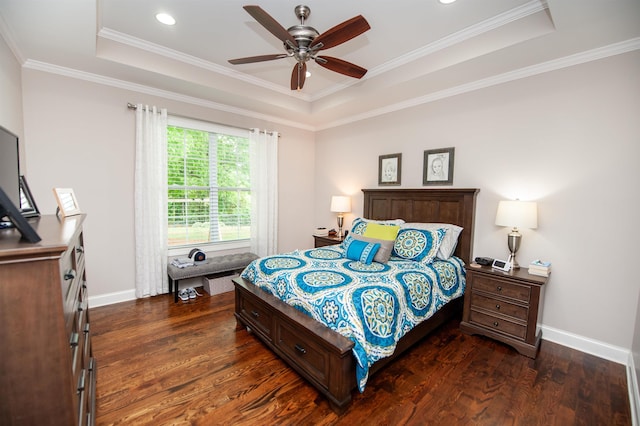bedroom with a tray ceiling, dark wood-style flooring, baseboards, ornamental molding, and recessed lighting