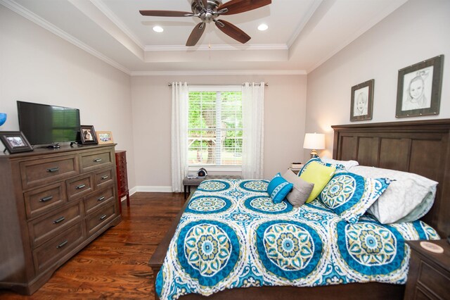 bedroom with a raised ceiling, dark wood-style floors, crown molding, recessed lighting, and baseboards