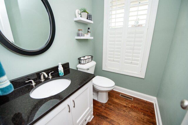 bathroom featuring wood finished floors, toilet, and vanity