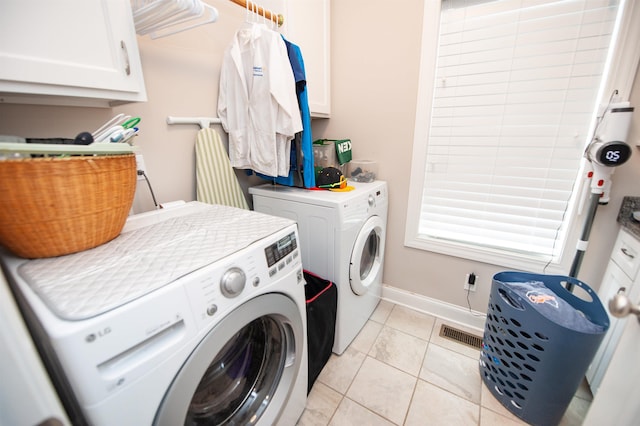 laundry room featuring washing machine and clothes dryer, cabinet space, baseboards, and light tile patterned floors