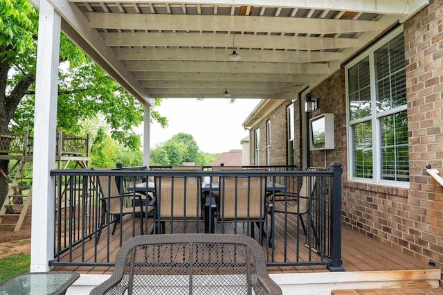 view of wooden balcony featuring outdoor dining space and a wooden deck