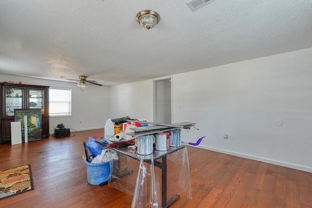 rec room featuring a textured ceiling, wood finished floors, ceiling fan, and baseboards
