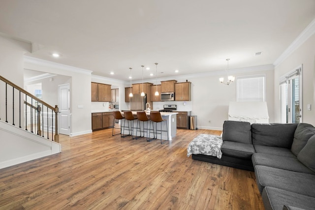 living room with light wood-style flooring, a chandelier, crown molding, stairway, and baseboards
