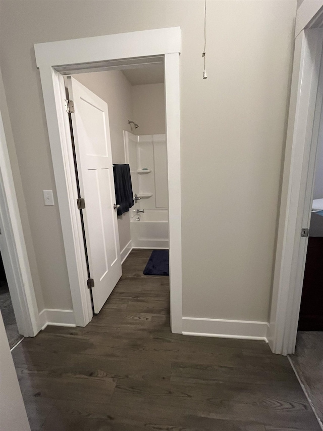 hallway with baseboards and dark wood-type flooring