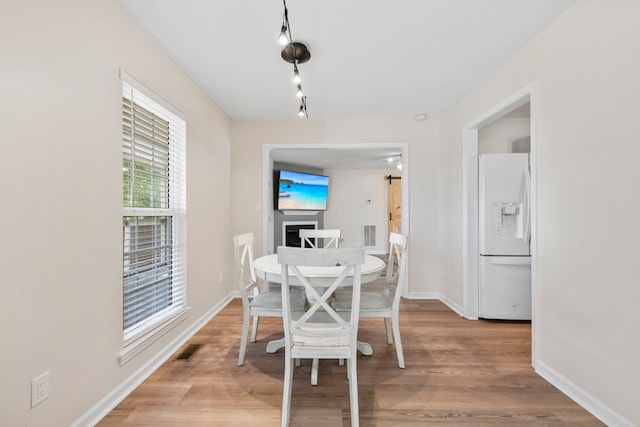 dining space with baseboards and light wood-type flooring