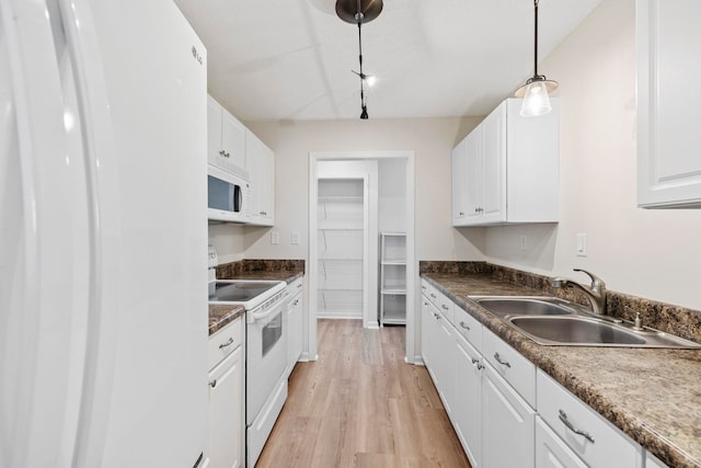 kitchen featuring white appliances, a sink, white cabinetry, and light wood-type flooring