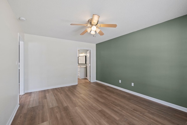 spare room with a ceiling fan, wood finished floors, a smoke detector, and baseboards