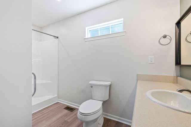 full bath featuring wood finished floors, a shower, toilet, and baseboards