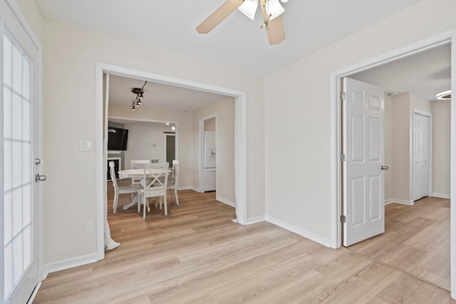 hall with light wood-style flooring and baseboards