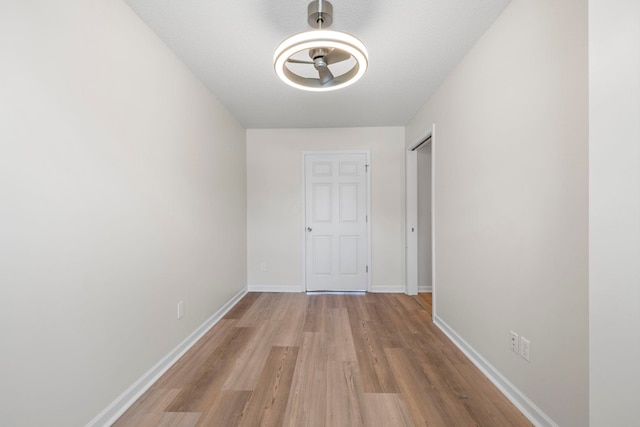 corridor with wood finished floors and baseboards