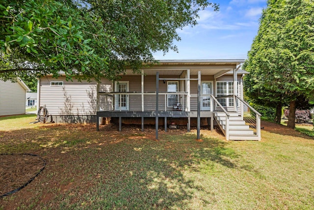 rear view of house with covered porch and a yard
