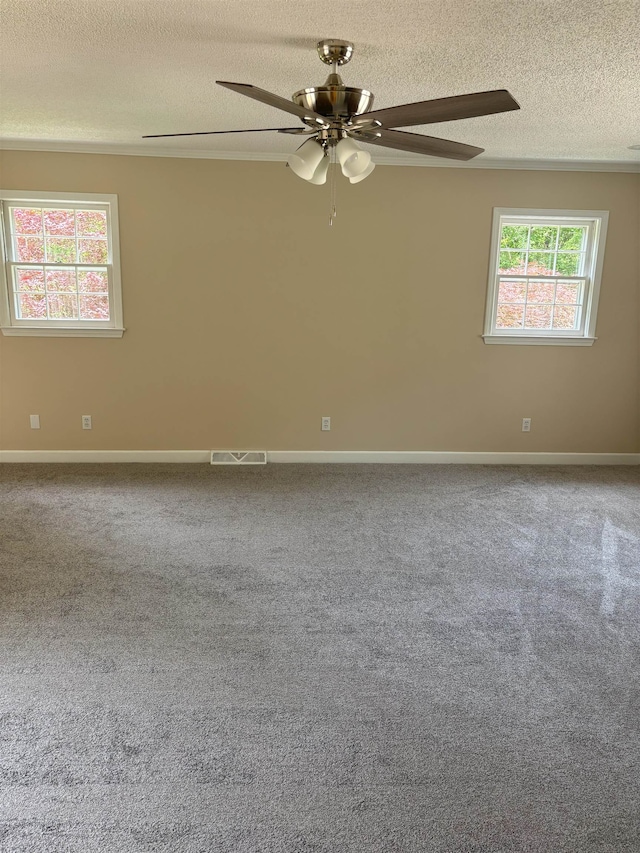carpeted empty room featuring a ceiling fan, a textured ceiling, and baseboards